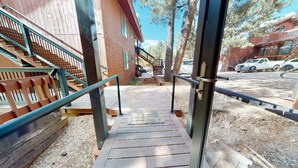 Eine Holztreppe führt zu einem Gebäude mit einem Metallgeländer.