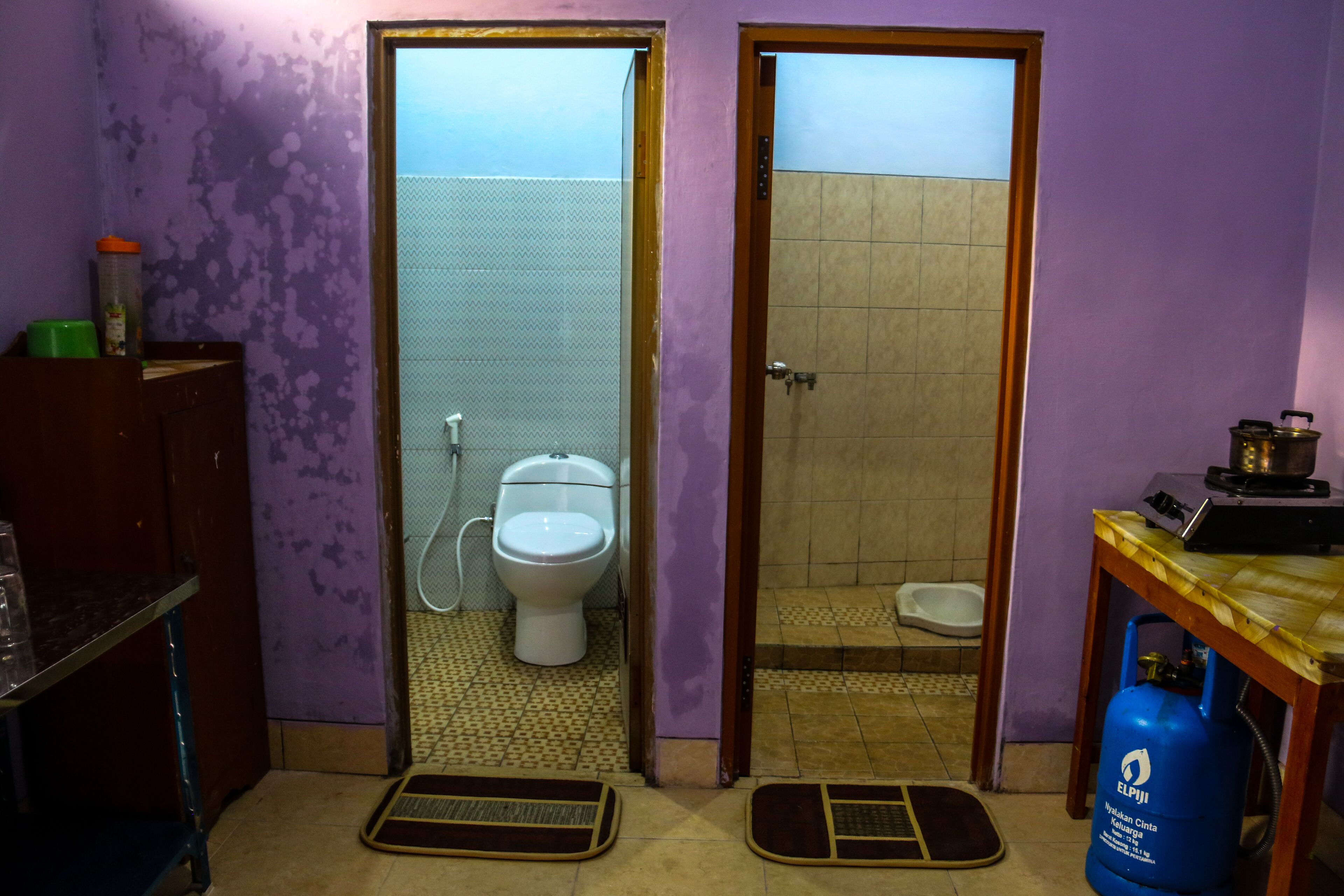 Un baño con inodoro, ducha y cilindro de gas.