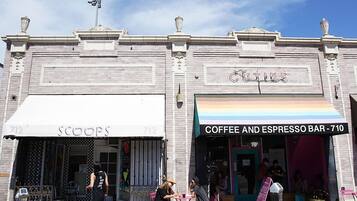 A building with a coffee and espresso bar, a store named 'SCOOPS', and a parking meter.
