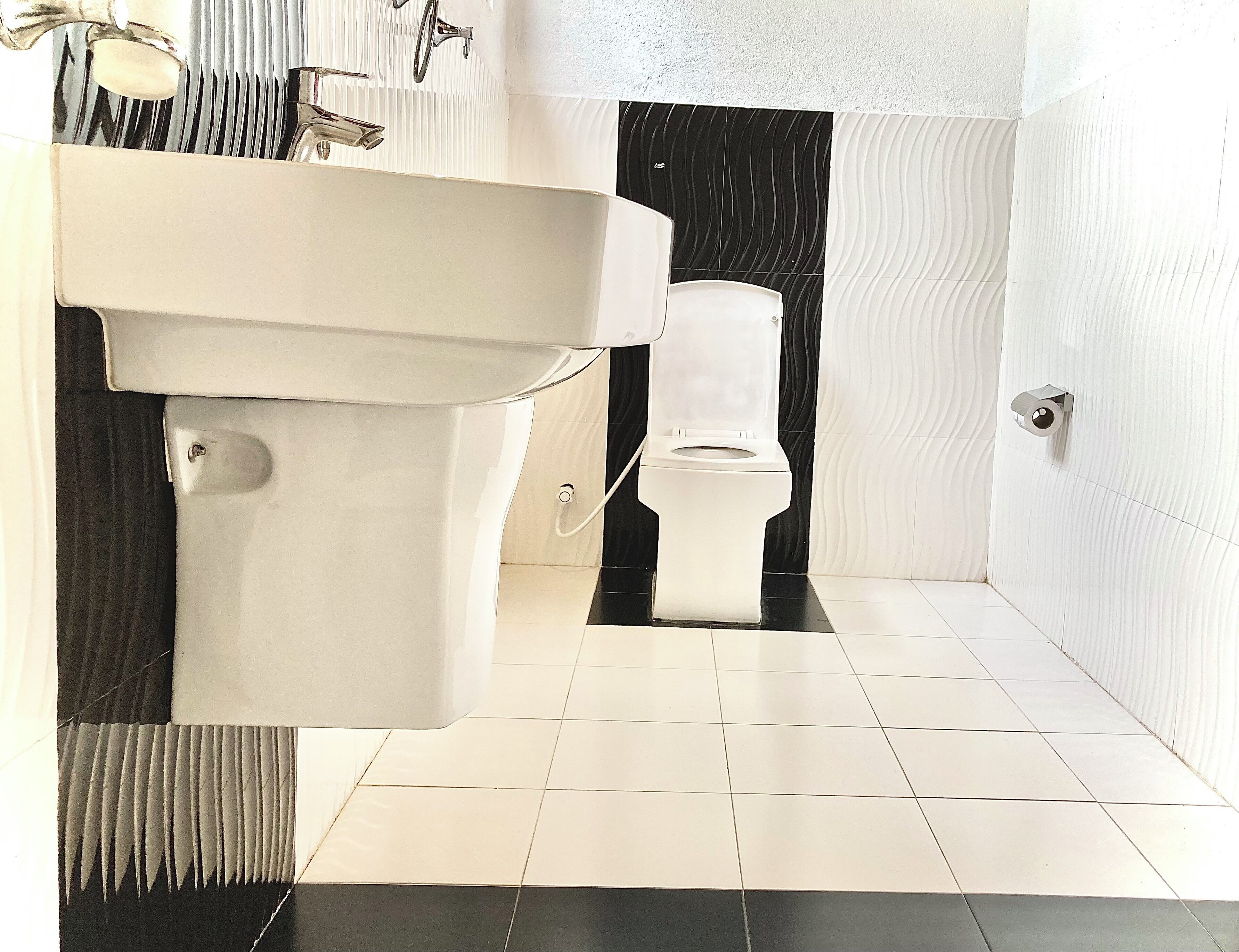 Un bagno con lavandino bianco, water e zona doccia.