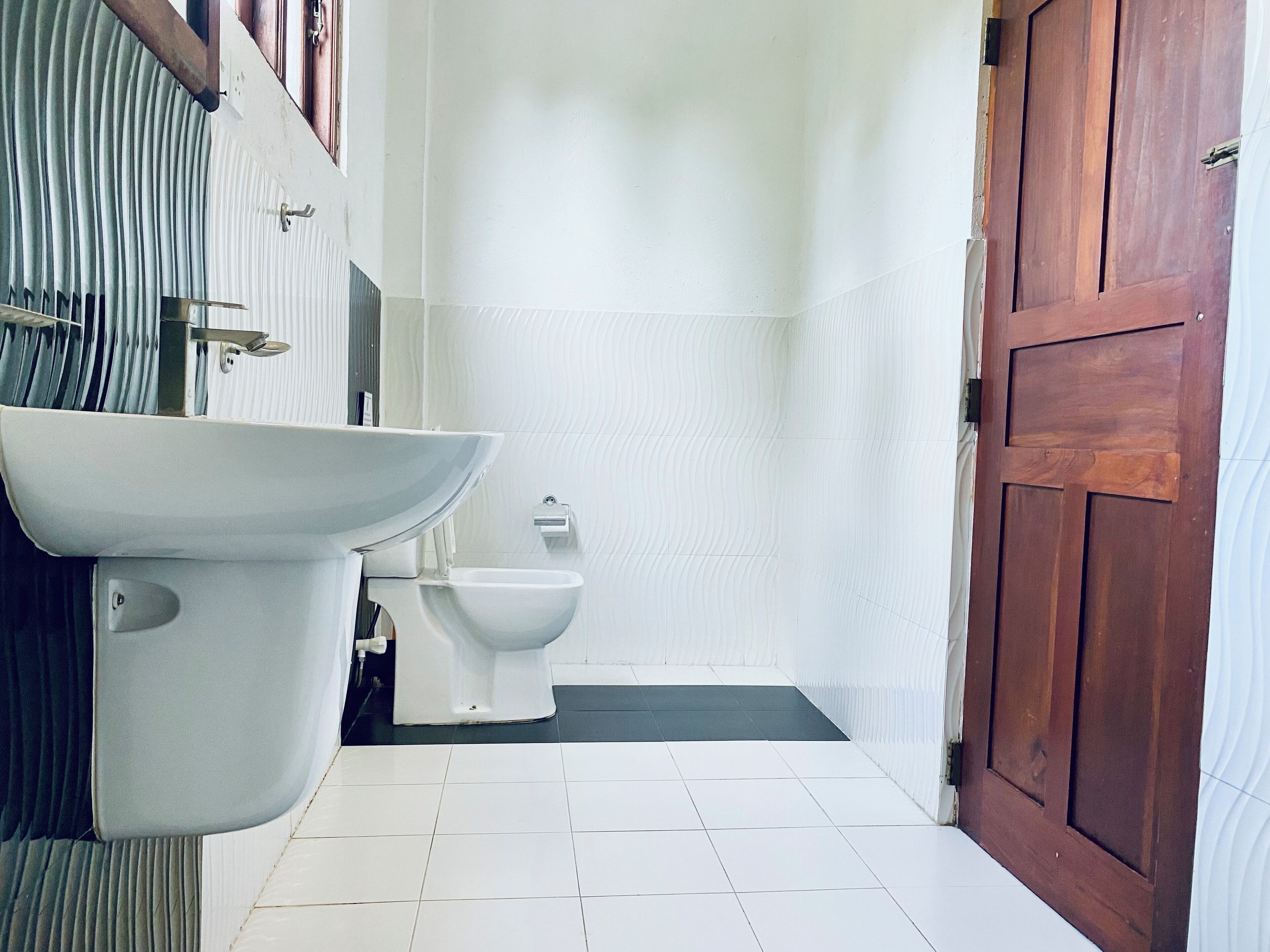 Un baño con un lavabo blanco, un inodoro y una zona de ducha.
