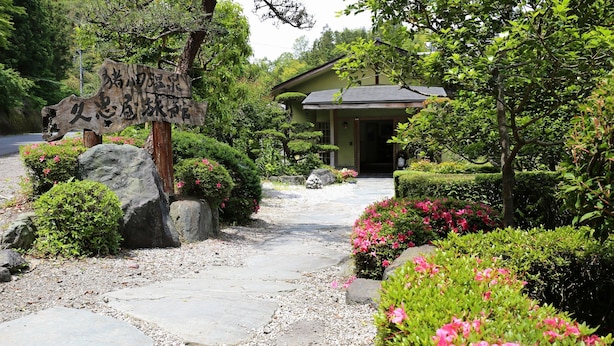A traditional Japanese-style building with a stone pathway leading to the entrance. - Hisaeya Ryokan (Fujioka)