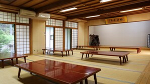A traditional Japanese room with tatami mats, wooden tables, and sliding doors. - Hisaeya Ryokan (Fujioka)