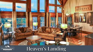 A spacious living room with a large window, a dining area, and a cozy seating area.