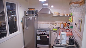 A compact kitchen with a refrigerator, stove, oven, and microwave. - Villanita (Punta Arenas)