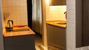 A compact kitchen with a modern design, featuring a built-in oven, a kettle, and a stainless steel sink. - Hermes Park Hotel Sisli (Istanbul)