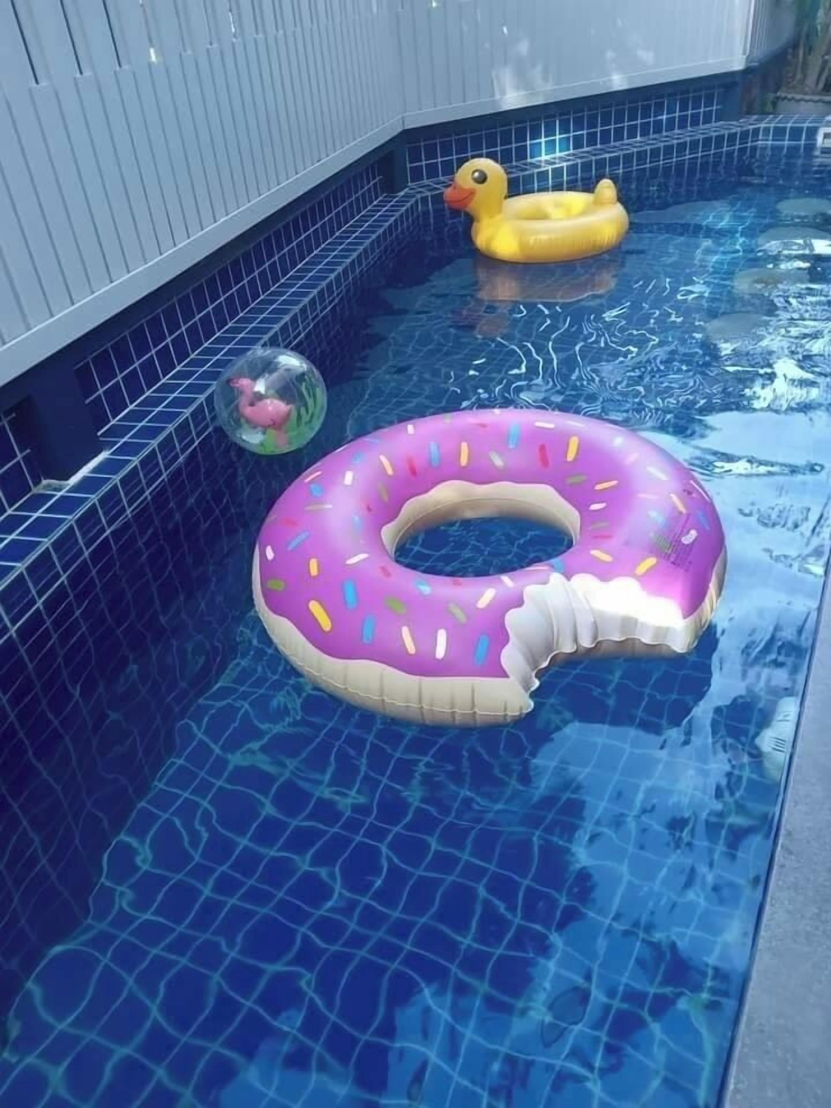 Een zwembad met een donut drijver en een eend drijver.