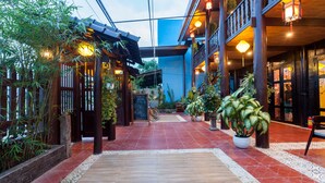 A traditional-style building with a wooden exterior, a tiled floor, and a balcony with hanging lanterns. - An Bang Stilt House (Da Nang)