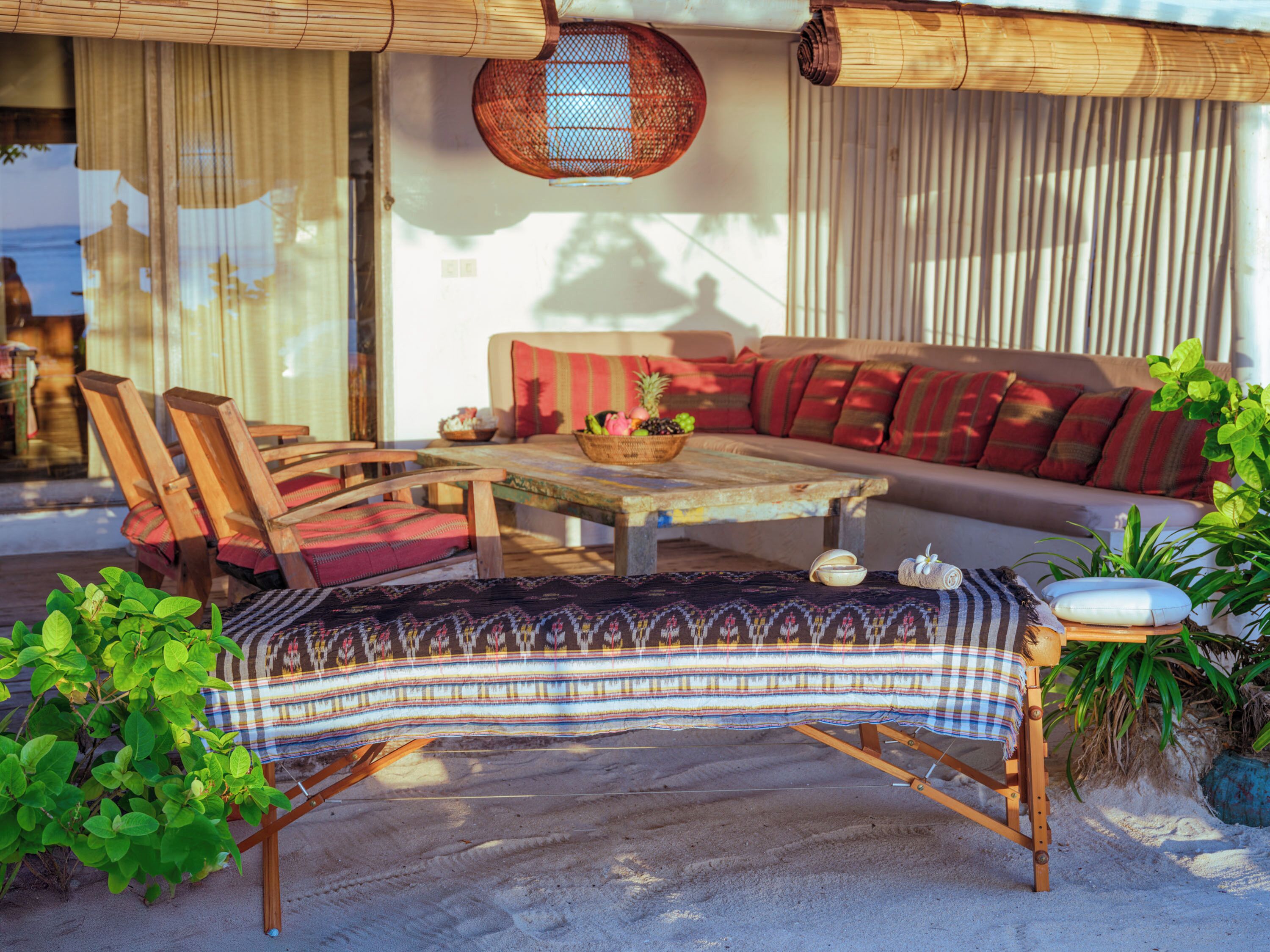 A cozy outdoor seating area with a wooden table, chairs, and a sofa.
