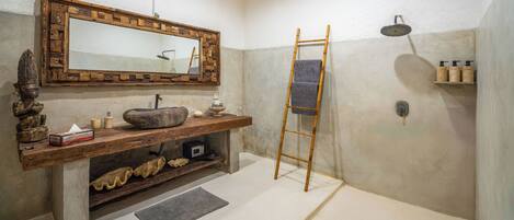 A bathroom with a wooden vanity, a large mirror, a bathtub, and a shower.