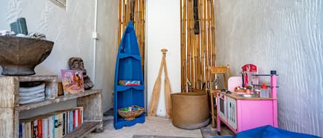 Una habitación acogedora con una estantería, una pequeña cocina y una cama.