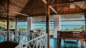 Una estructura al aire libre con techo de madera y vista al océano.