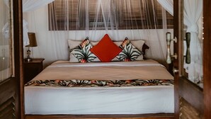 Una habitación con cama con dosel, una mesita de noche con lámpara y una ventana con persianas.