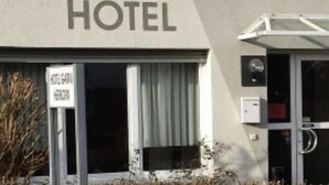 Ein Hotel Eingang mit Schild, das einen Check-in rund um die Uhr anzeigt.