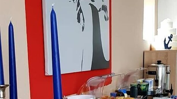 Ein Essbereich mit Buffet, darunter ein Brotkorb, eine Milchkaraffe und verschiedene Speisen.