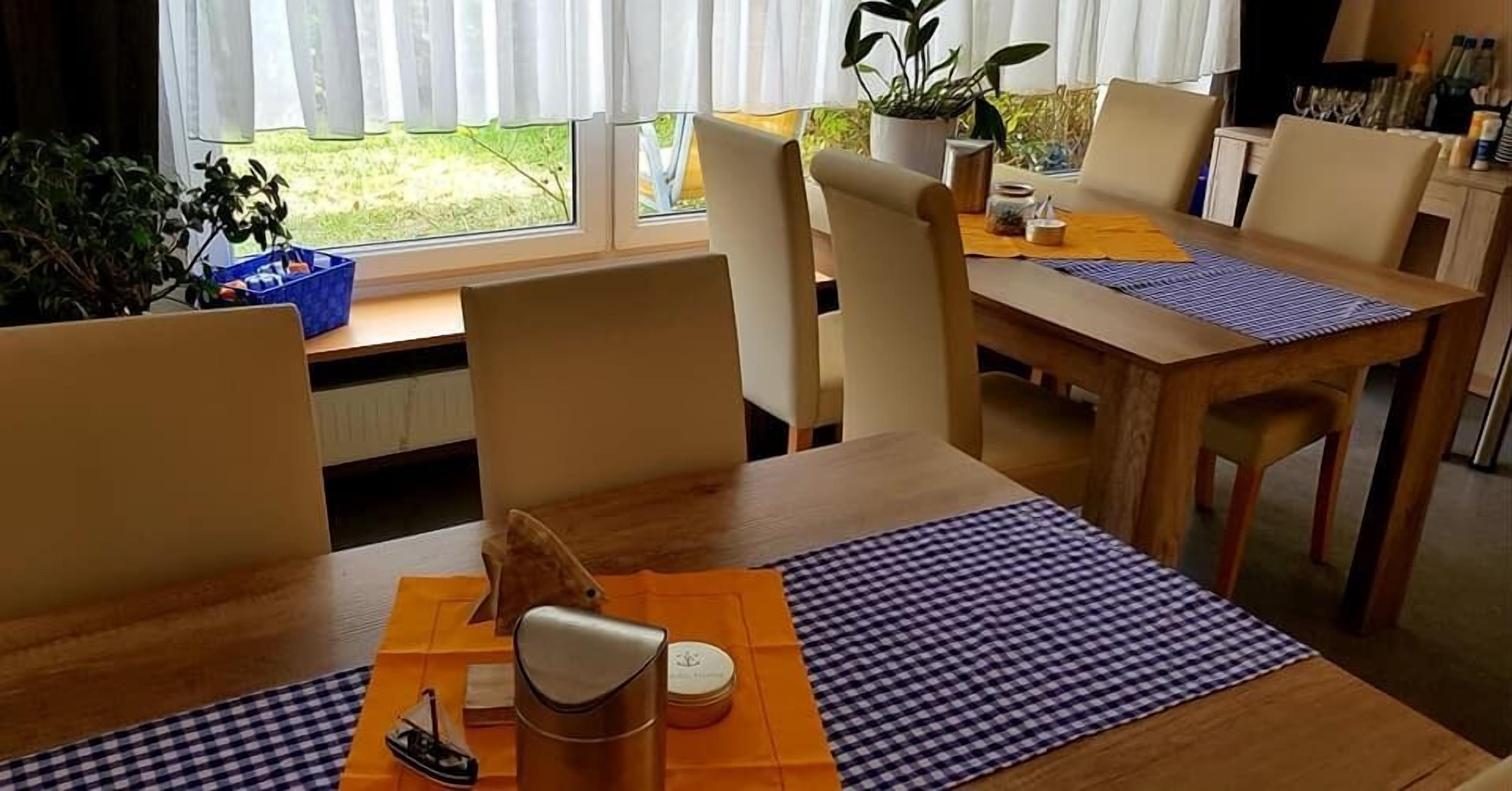A dining area with a wooden table, beige chairs, and a checkered table runner.