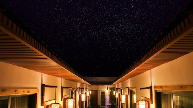 Un pasillo iluminado por faroles, con un cielo estrellado.