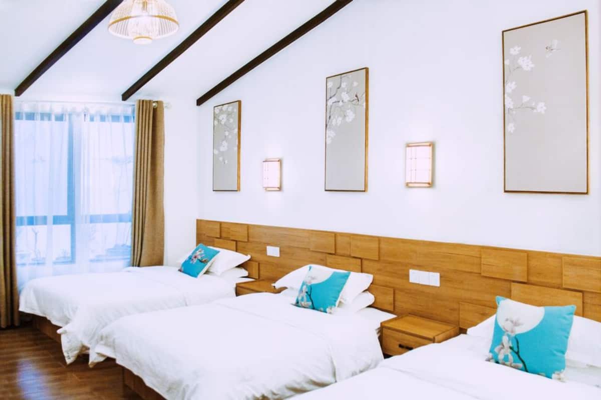 Una habitación de hotel con dos camas, cabeceros de madera y obras de arte en las paredes.