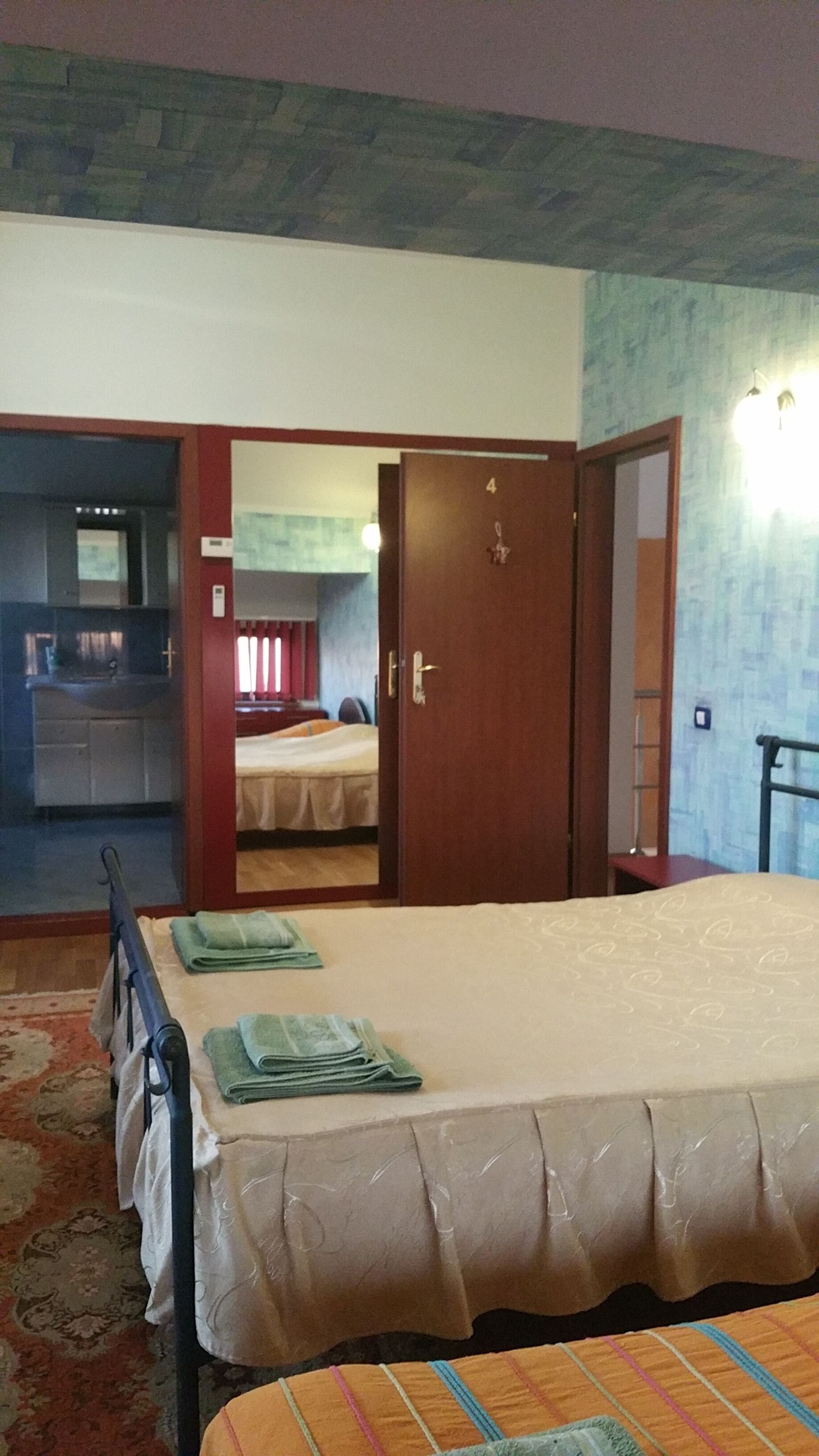 A bedroom with a bed, a bathroom, and a kitchen area.