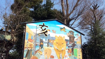 Un mural colorido en un edificio con varios animales y caracteres chinos.