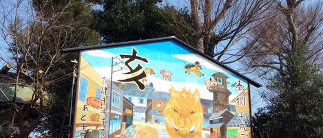 Un mural colorido en un edificio con varios animales y caracteres chinos.