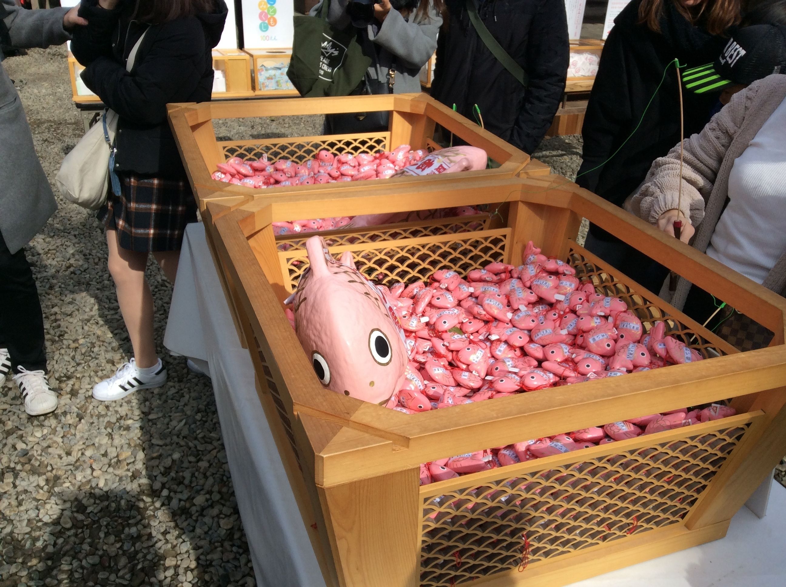 A display of pink packaged items in wooden crates at an outdoor event.