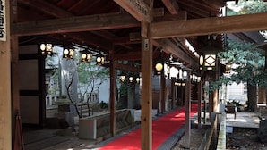 A covered walkway with a red carpet, wooden pillars, and hanging lanterns. - Kawagoe Dai-Ichi Hotel (Kawagoe)