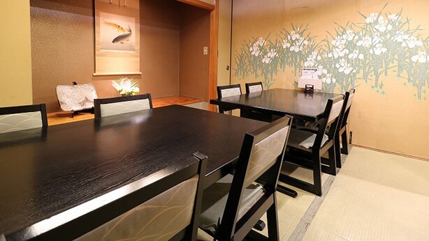 A conference room with a long table and chairs, a ceiling vent, and a wall with a floral mural. - Kawagoe Dai-Ichi Hotel (Kawagoe)