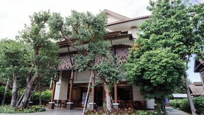 A traditional building with a tiled roof, surrounded by lush greenery and trees. - Lima Lanna Hotel (Chiang Mai)