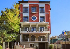 Un hotel de varios pisos con balcones y una entrada principal.