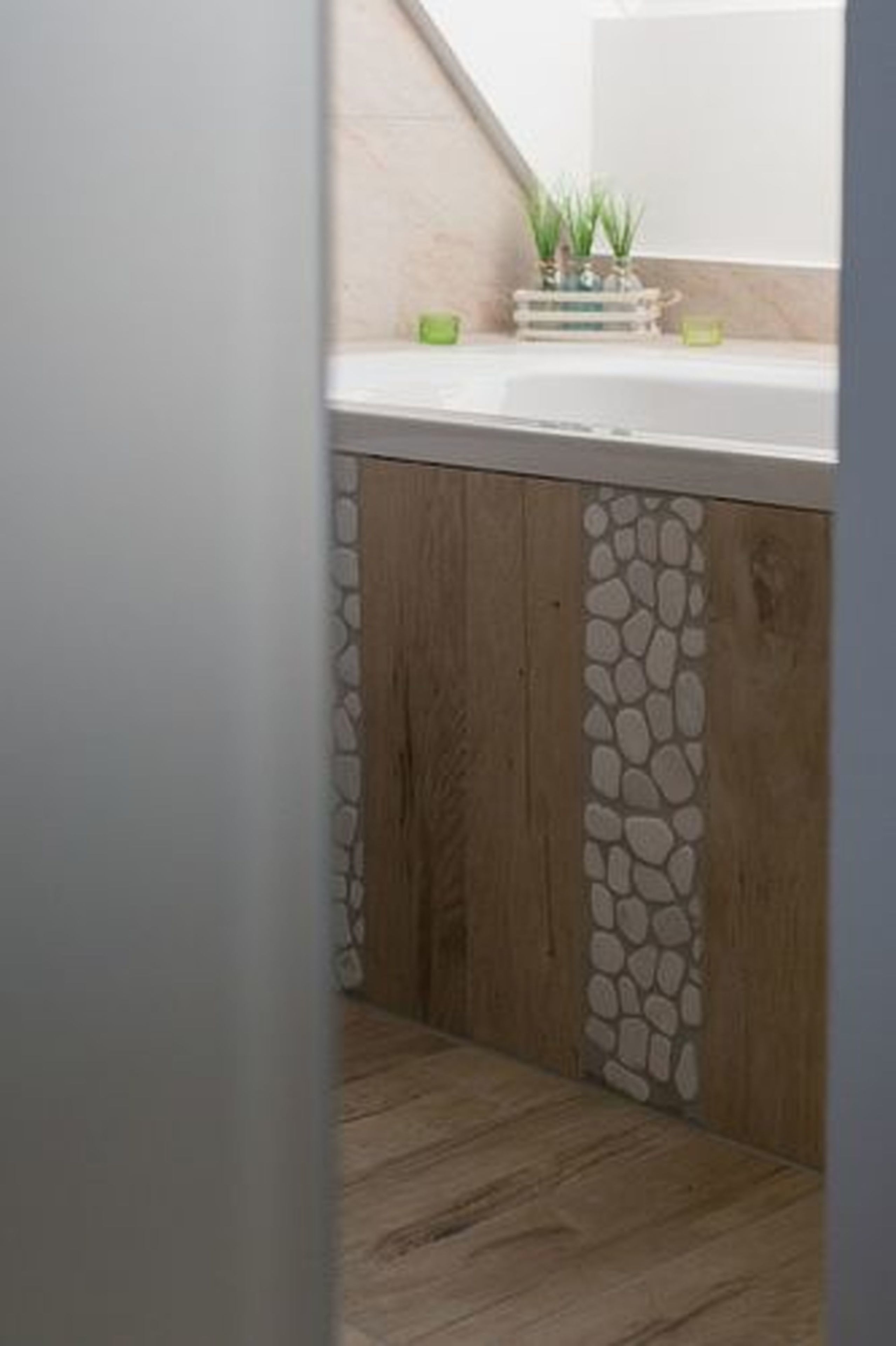 Una cocina con un armario de madera y una pared de acento de piedra.