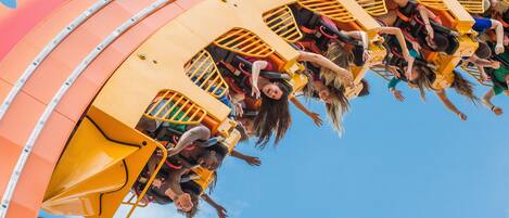 A roller coaster with passengers in yellow cars.