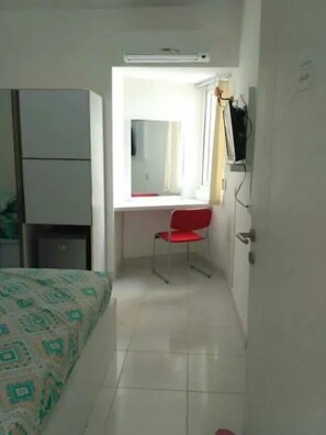 Cozy retreat with a bed, desk, and TV, perfect for a comfortable stay.