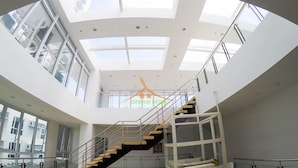A modern interior with a central staircase, large windows, and a skylight. - Your Dream Home at Abreeza Davao (Davao)