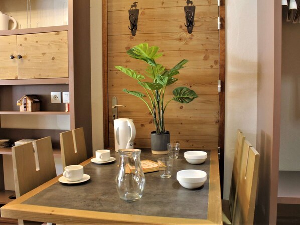 Enjoy a romantic dinner for two in this inviting dining area, complete with a beautifully set table and a touch of greenery.