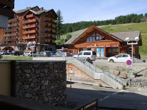 Stunning mountain views surround this resort lodge with a steeply pitched roof and large windows.