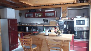 Una cocina con armarios de madera, microondas y refrigerador.