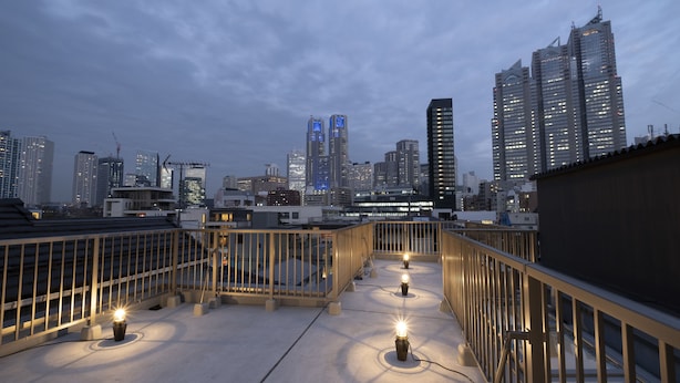 A rooftop terrace with a view of a city skyline at dusk. - STUDIO INN NISHISHINJUKU (Tokyo)