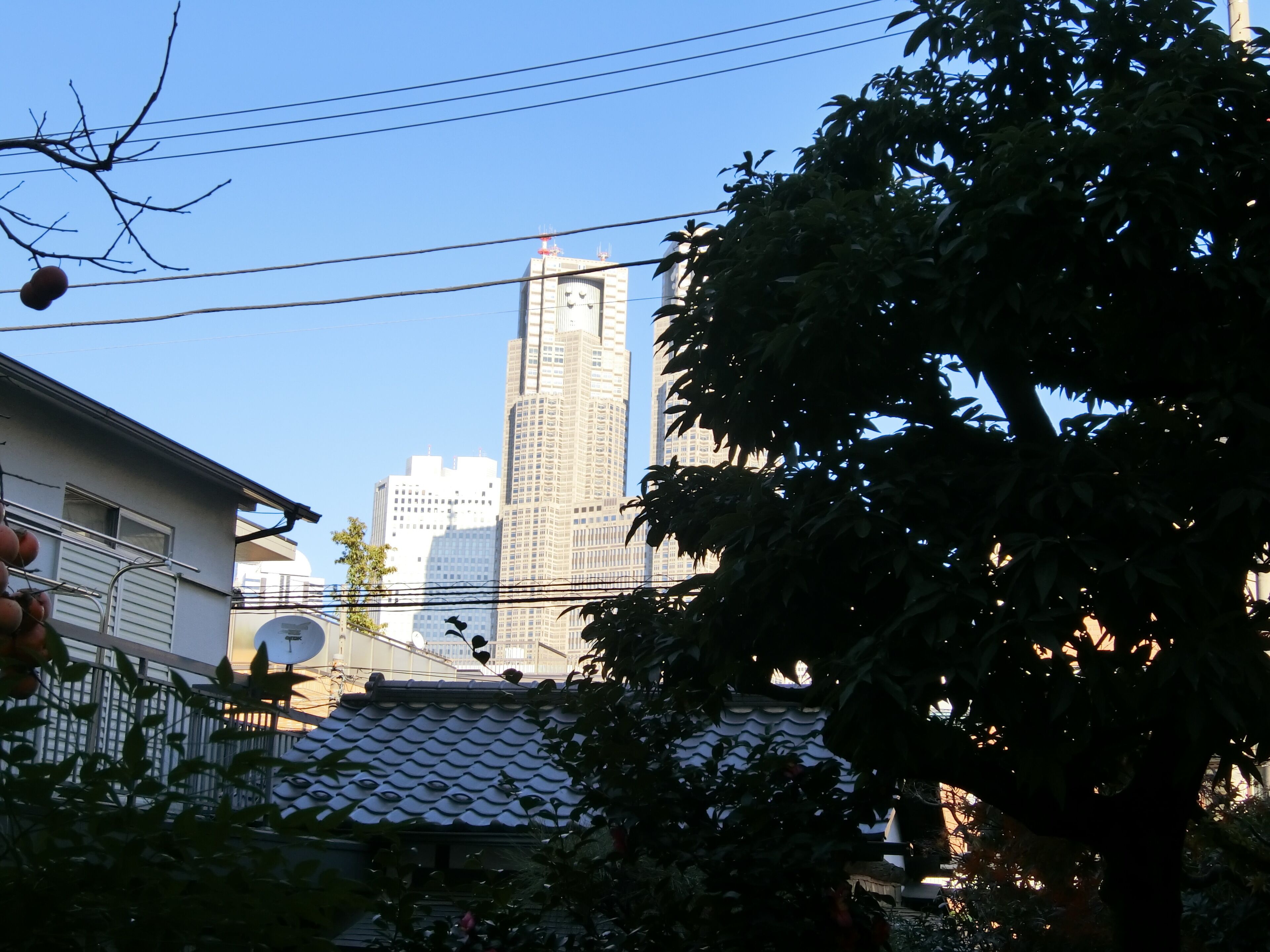 Perinteinen japanilainen rakennus, jossa on tiilikatto, ja sen ympärillä kohoaa moderneja pilvenpiirtäjiä.