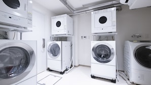 A laundry room with multiple stacked washing machines and dryers. - STUDIO INN NISHISHINJUKU (Tokyo)