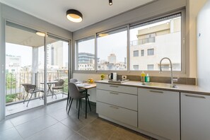 Apartamento conforto, 1 quarto | Cozinha privada | Geladeira grande, micro-ondas (mediante solicitação), fogão, cooktop