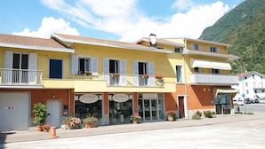 A yellow building with multiple storefronts, including a visible sign for 'LAVINERA.' - Ca' Elsa Bed & Breakfast (Dubino)
