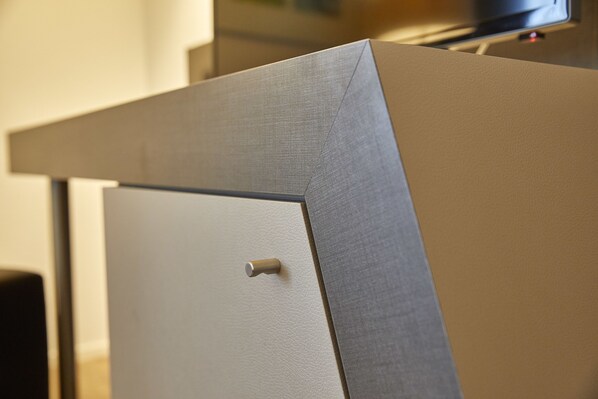 A corner of a room with a beige wall and a door with a textured surface. - Hotel Berchtold (Burgdorf)