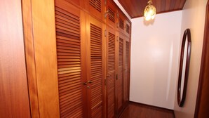A hallway with wooden sliding doors and a mirror on the wall. - Pousada Recanto Paulista (Campos do Jordão)