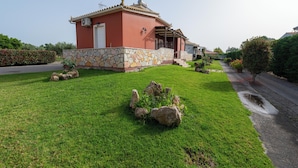 A house with a stone foundation, a red facade, and a small porch. - Spedion Villa Gytheio (East Mani)