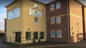 The Orchard Hotel Gloucester with a two-story structure, a flat roof, and a brick facade. - the orchard hotel (Quedgeley)