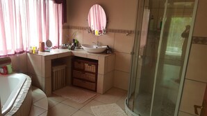 Un bagno con lavandino, specchio e doccia.