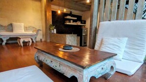 A spacious living area with a wooden coffee table, white sofas, and a kitchen area in the background. - WOODEN Home Top LOCATION in Seminyak Near Beach, Shops, Restaurants (seminyak)