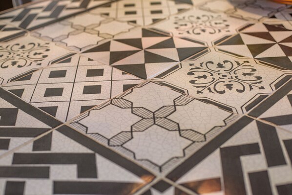 A close-up of a patterned tile floor with geometric and floral designs.
