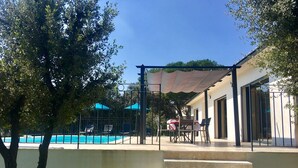 A pool area with a covered patio, outdoor seating, and a staircase leading to a building. - PRETTY NEW AIR CONDITIONED VILLA WITH HEATED POOL IN THE CAMPAIGN OF UZES (UZES)